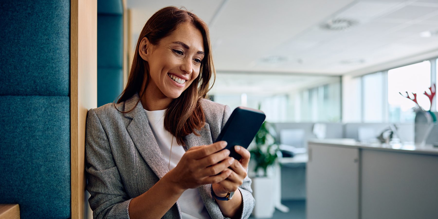A woman reading a job posting on her phone at work